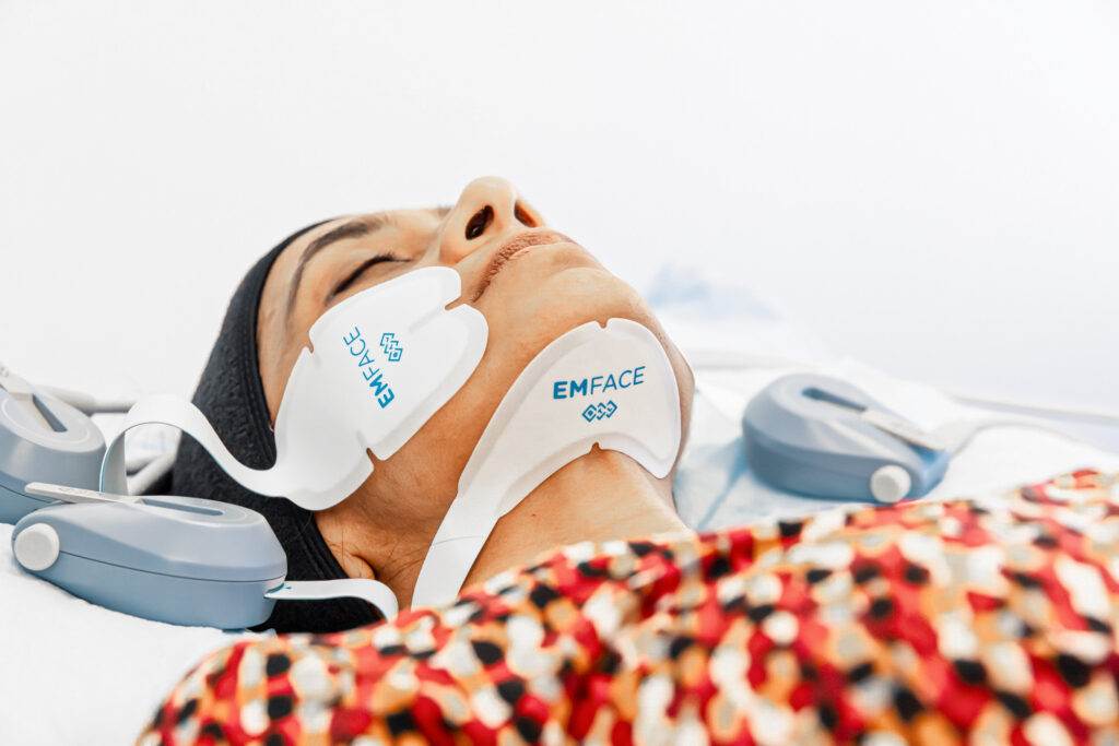 A patient shuts her eyes and reclines while she receives a treatment with Emface near McLean.